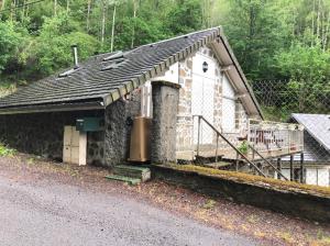 a small stone building with a porch on the side of a road at NANA 63 in La Bourboule