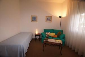 a room with a bed and a green couch and a table at Casa Belvedere (CITRA 008026-LT-0015) in Diano Castello