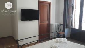 a bedroom with a bed with a flat screen tv at DonMattè - Charme & Rooms in Conversano