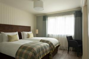 a hotel room with two beds and two lamps at The Glencoe Inn in Glencoe
