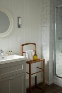 a bathroom with a sink and a bath tub at The Glencoe Inn in Glencoe