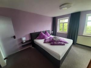 ein Schlafzimmer mit lila Wänden und ein Bett mit lila Kissen in der Unterkunft Landhotel Weisses Röß`l in Adorf