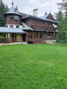 una grande casa con un cortile verde davanti di Leśna Skawica a Skawica