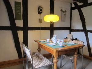une table à manger avec des chaises et une lampe jaune dans l'établissement Ferienhaus Zum alten Standesamt, à Weenzen
