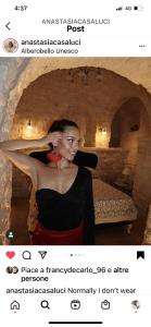 a woman standing in a room with a bed at Trulli e Puglia Luxury Suite in Alberobello