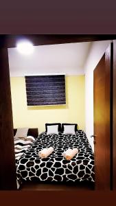 a bedroom with a black and white bed with two pillows at Karbula Apartments & Villa in Mavrovo