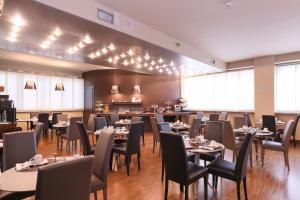 ein Restaurant mit Tischen und Stühlen in einem Raum in der Unterkunft Hotel Aleramo in Asti