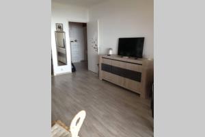 a living room with a flat screen tv on a dresser at T2 Sanguinaires calme et cosy, entre mer et maquis in Ajaccio
