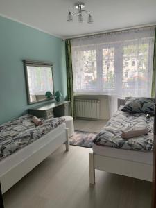 クリニツァ・ズドルイにあるApartament Kraszewskiegoのベッドルーム1室(ベッド2台、窓2つ付)