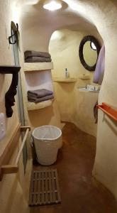 a bathroom with a bucket in a room with towels at Rockwood Earth Lodge in Champagne Valley