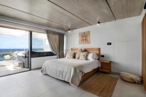 Un dormitorio con una cama grande y una ventana grande. en Gran Suite Horizonte, en Puerto del Carmen