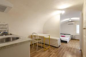 een keuken met een wastafel en een bed in een kamer bij Appartamento piccolo nel cuore della citta' by Wonderful Italy in Bologna