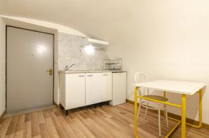 een kleine keuken met een tafel en een gele stoel bij Appartamento piccolo nel cuore della citta' by Wonderful Italy in Bologna