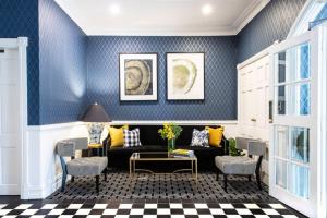 a living room with blue walls and a couch and chairs at voco™ Kirkton Park Hunter Valley, an IHG Hotel in Pokolbin