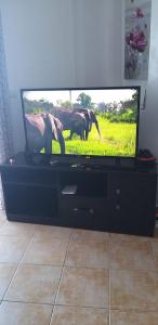 een flatscreen-tv op een zwart entertainmentcentrum bij Smir Park in Tetouan
