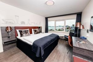 a bedroom with a bed and a desk and a window at Radisson Blu Limfjord Hotel, Aalborg in Aalborg
