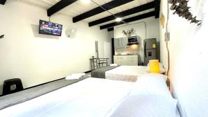 a room with two beds and a tv on the wall at Jardin Loft in Medellín