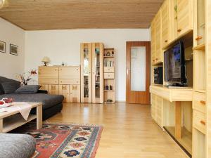 een woonkamer met een bank en een tv bij Ferienwohnung Zucker in Grafenau