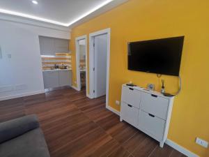 een woonkamer met een flatscreen-tv aan een gele muur bij Sorrento Punto It Apartment in Sorrento