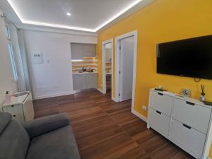 een woonkamer met een bank en een flatscreen-tv bij Sorrento Punto It Apartment in Sorrento