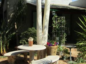 een patio met een tafel, stoelen en planten bij Serendipity NO TV in Polokwane