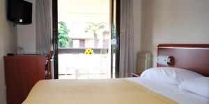 sypialnia z łóżkiem i drzwiami prowadzącymi na patio w obiekcie Hotel Derby w Sirmione