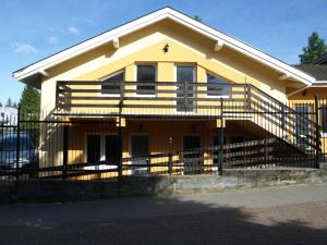 a yellow house with a fence in front of it at Pokoje Gościnne - Noclegi Charzykowy in Charzykowy