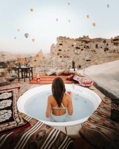 a woman sitting in a jacuzzi tub with a view at Seki Cave Suites in Goreme