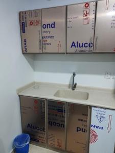 eine Küche mit einem Waschbecken und Schachteln an der Wand in der Unterkunft ريـــــم للشقق المفروشة والأجنحــة الفـندقيـة Reem Hotel in Khobar