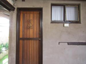 a wooden door on the side of a house at Serendipity NO TV in Polokwane