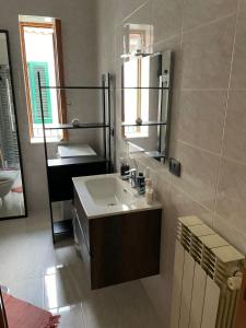 een badkamer met een wastafel en een spiegel bij La Casa di Giù in Pozzuoli