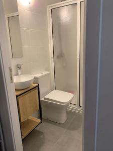 een badkamer met een toilet, een wastafel en een douche bij Shining in Funchal