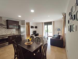 a kitchen and a living room with a table and chairs at Apartamentos El Valle in Bubaces