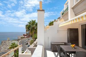 een balkon met een tafel en stoelen en uitzicht op de oceaan bij Sea View Apartment en Mogán in Playa del Cura