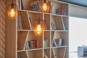 two lights hanging from a book shelf with books at Nura Santa Ponsa & Spa in Santa Ponsa
