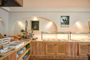 a restaurant with a counter with food on it at Nura Santa Ponsa & Spa in Santa Ponsa