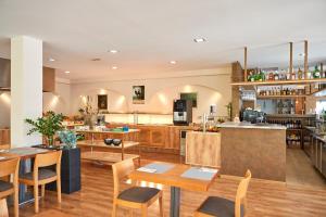 a large kitchen with wooden tables and chairs at Nura Santa Ponsa & Spa in Santa Ponsa