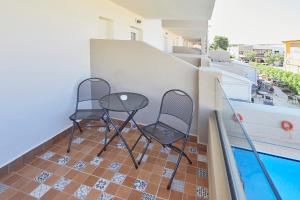 two chairs and a table on a balcony with a pool at Nura Santa Ponsa & Spa in Santa Ponsa