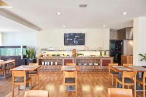 a restaurant with wooden tables and chairs and a kitchen at Nura Santa Ponsa & Spa in Santa Ponsa