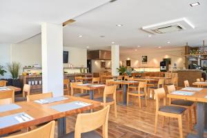 a dining room with wooden tables and chairs at Nura Santa Ponsa & Spa in Santa Ponsa