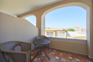 a balcony with two chairs and a table and two windows at Nura Santa Ponsa & Spa in Santa Ponsa