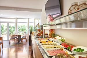 a kitchen with a buffet with many different types of food at Nura Santa Ponsa & Spa in Santa Ponsa