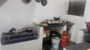 a kitchen with a stove and some pots and pans at Gopi Plantation Homestay in Hampi