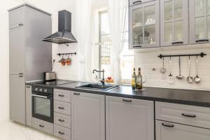 a kitchen with white cabinets and a sink at Apartment Augier - Elegant & Spacious - City Centre in Pula