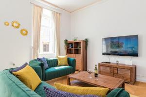 a living room with two green couches and a table at Apartment Augier - Elegant & Spacious - City Centre in Pula