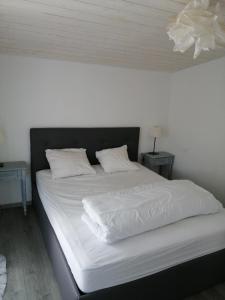 a large bed with white sheets and pillows on it at Charmante maison à 500 m de la côte, pour 4 in Notre-Dame-de-Monts