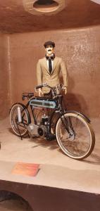 a statue of a man with a motorcycle on display at Museo Posada Benelli in San Rafael