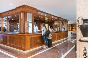 Una mujer parada en un mostrador de una tienda en Hotel Torre Azul & Spa - Adults Only, en El Arenal 37 fotos más