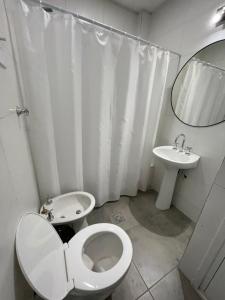 een witte badkamer met een toilet en een wastafel bij CASA PIETRO in Mendoza