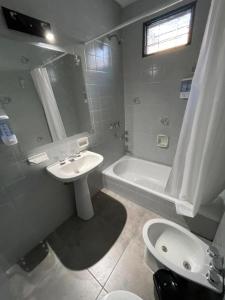 een badkamer met een wastafel, een toilet en een bad bij CASA PIETRO in Mendoza